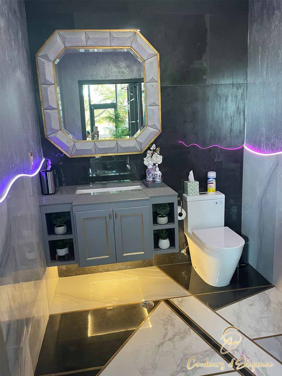 A commercial bathroom featuring various tiles, neon light accents and glitter walls.