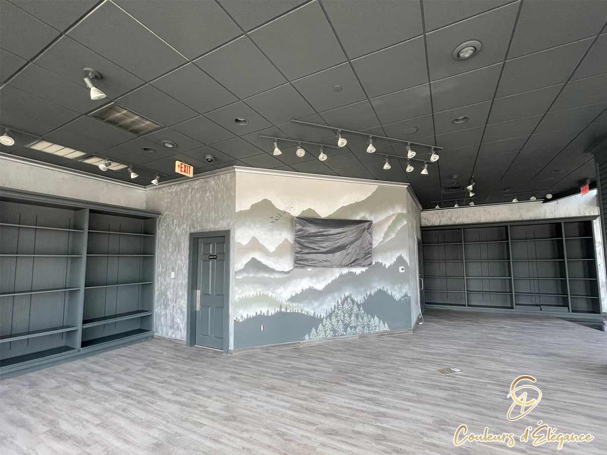 A large commercial space featuring a hand painted forest and mountain mural.