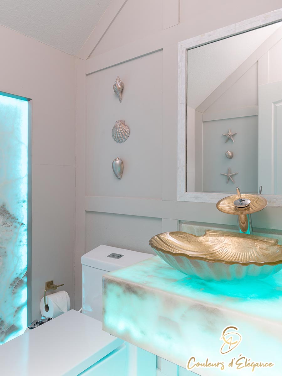 A residential bathroom with a golden seashell sink on a color changing basin.