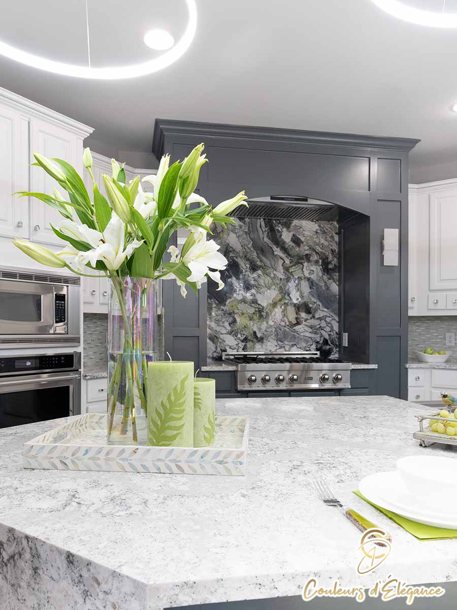 A beautifully designed residential kitchen featuring the island and stove area with a bouquet of lilies.