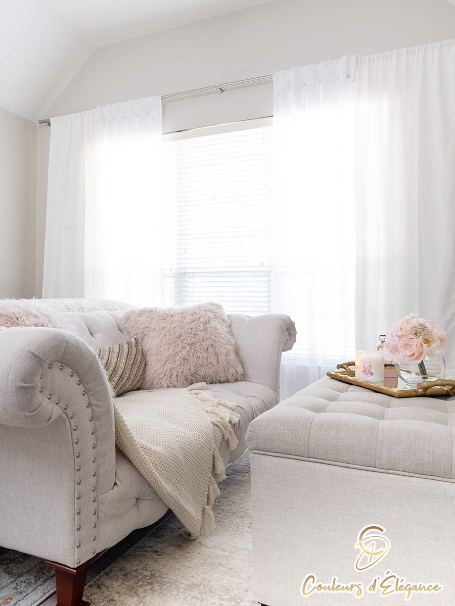 A loveseat in front of a softly lit window.