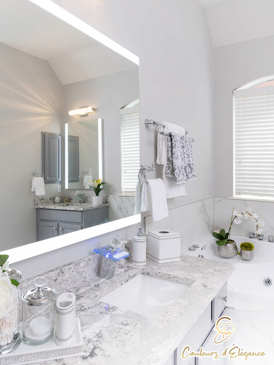 A beautifully designed master bath featuring a unique faucet and lighted mirror.