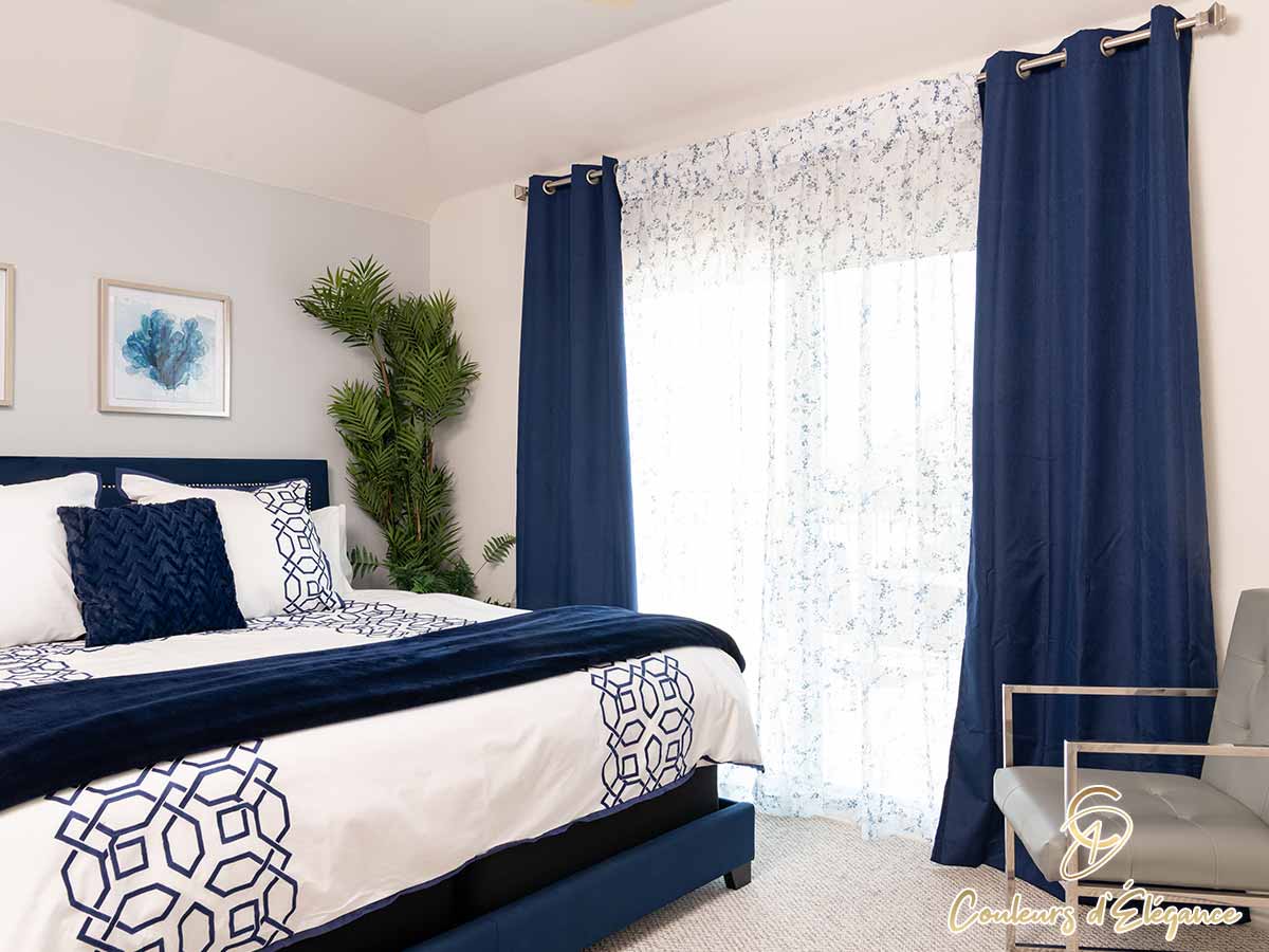 Blue drapes with lacy sheers in a beautifully designed bedroom.
